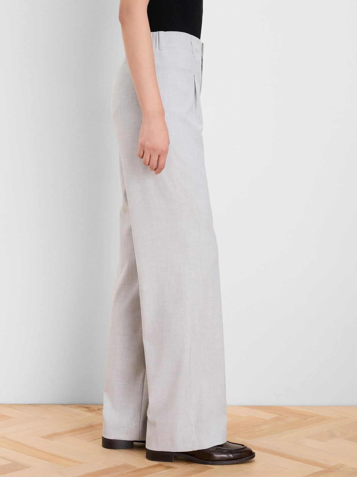 Light grey, high-waisted wide leg trousers with a subtle front pleat, shown on a model.