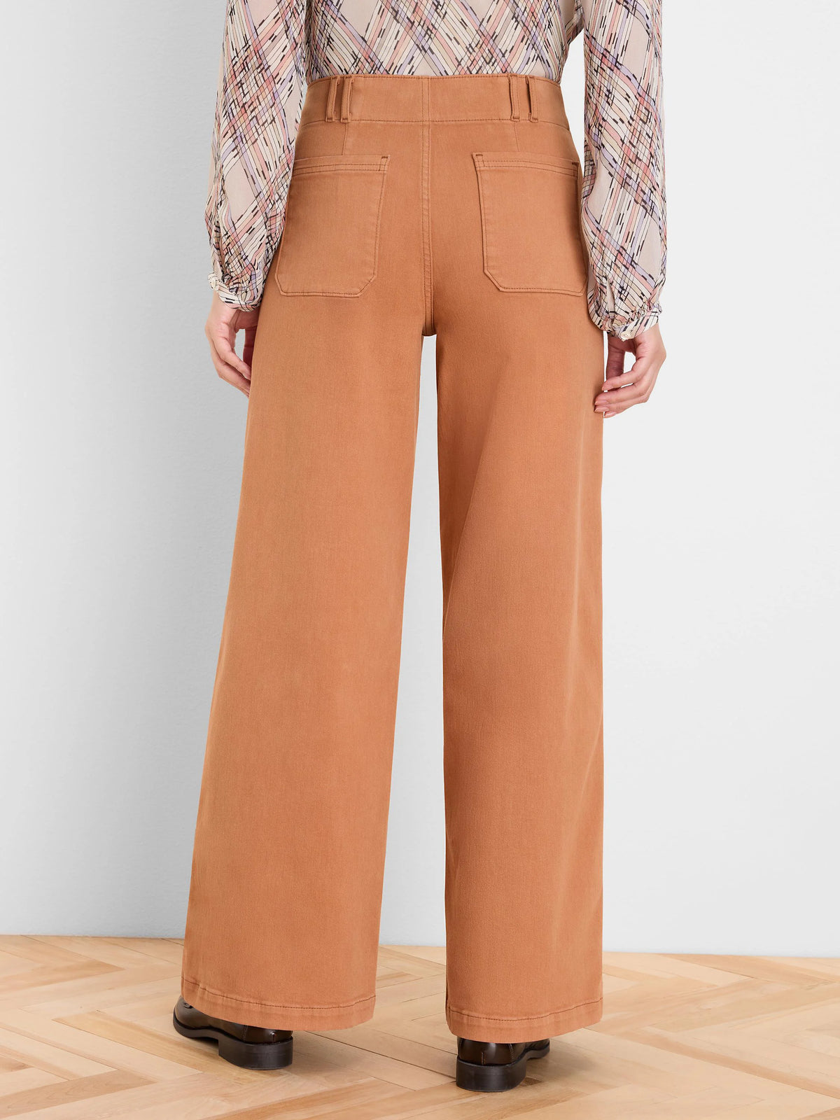 Rust wide-leg jeans shown from behind. Features include belt loops and two back patch pockets.