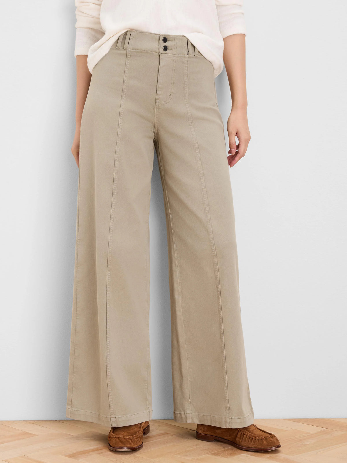 Tan wide leg jeans with prominent vertical front seams down each leg and two dark buttons at the waistband.