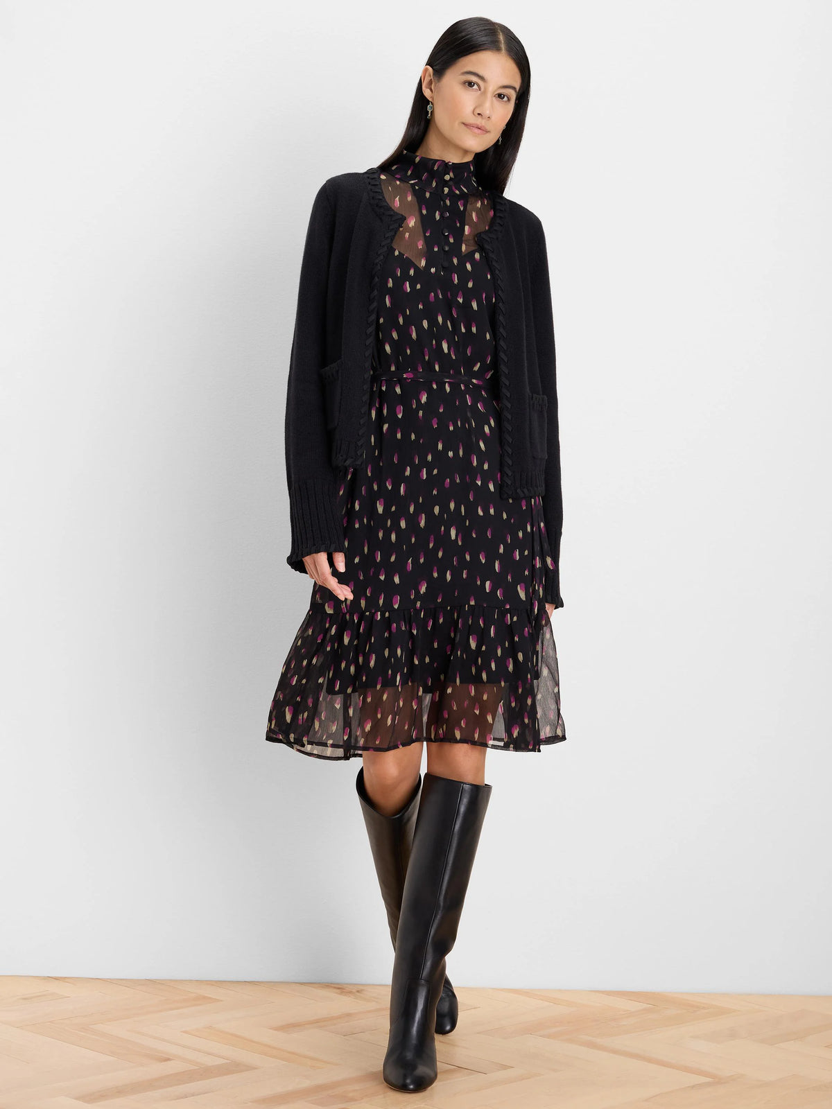 Black dress with magenta/gold petal dots. High neck, sheer bodice, cinched waist, tiered knee-length skirt.