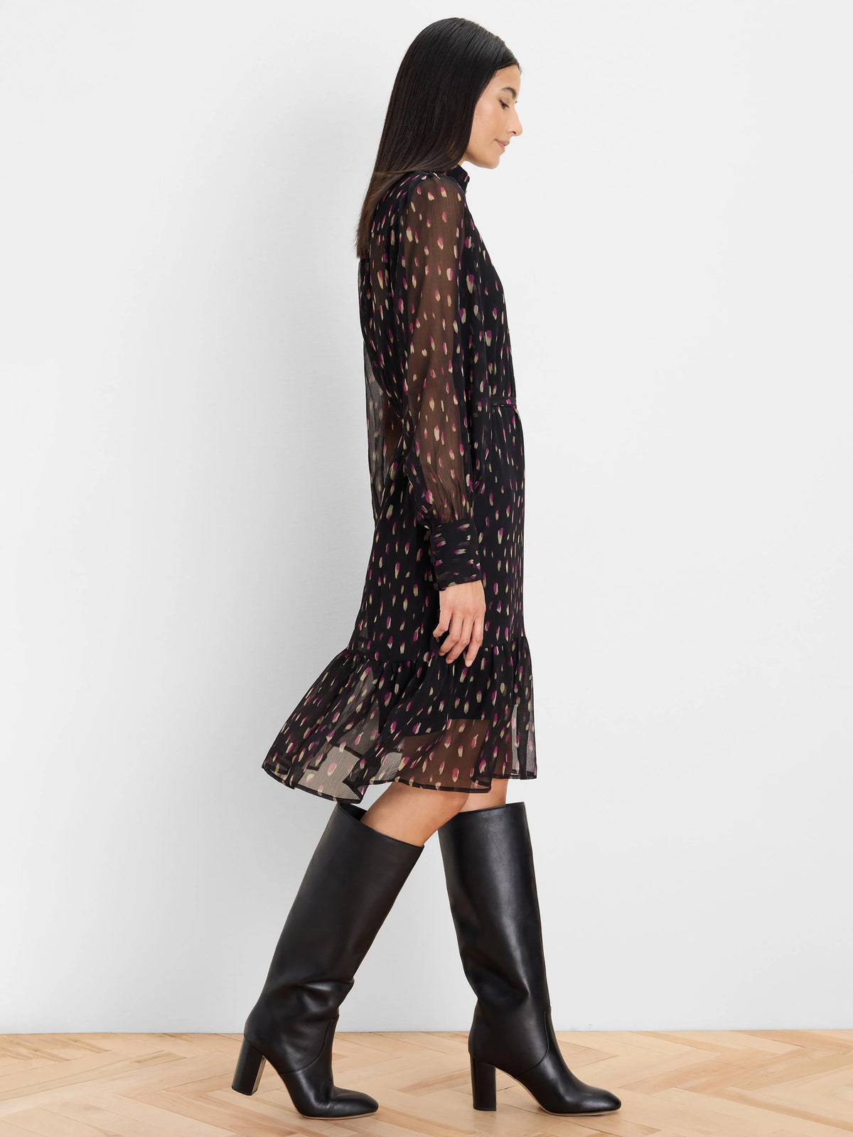 Black sheer long-sleeve dress with purple and gold petal-like dashes and a tiered ruffled hem.