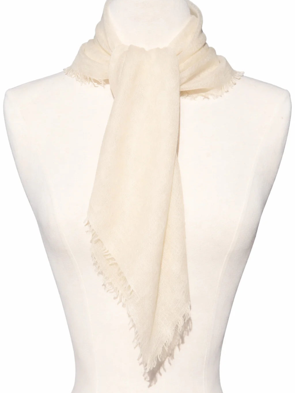 Cream scarf with frayed edges, tied on a mannequin.
