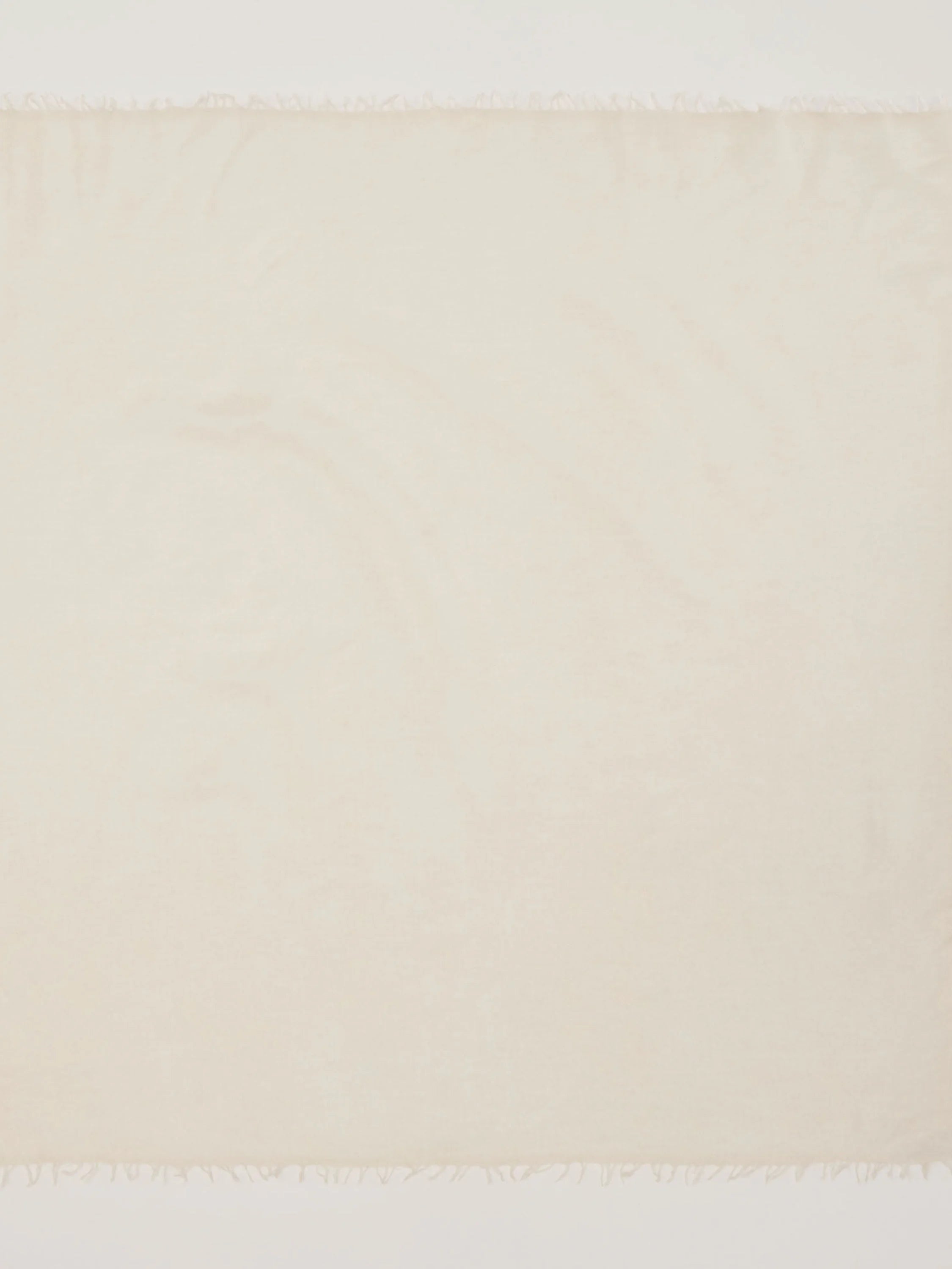 Cream cashmere neck scarf with fringed ends.