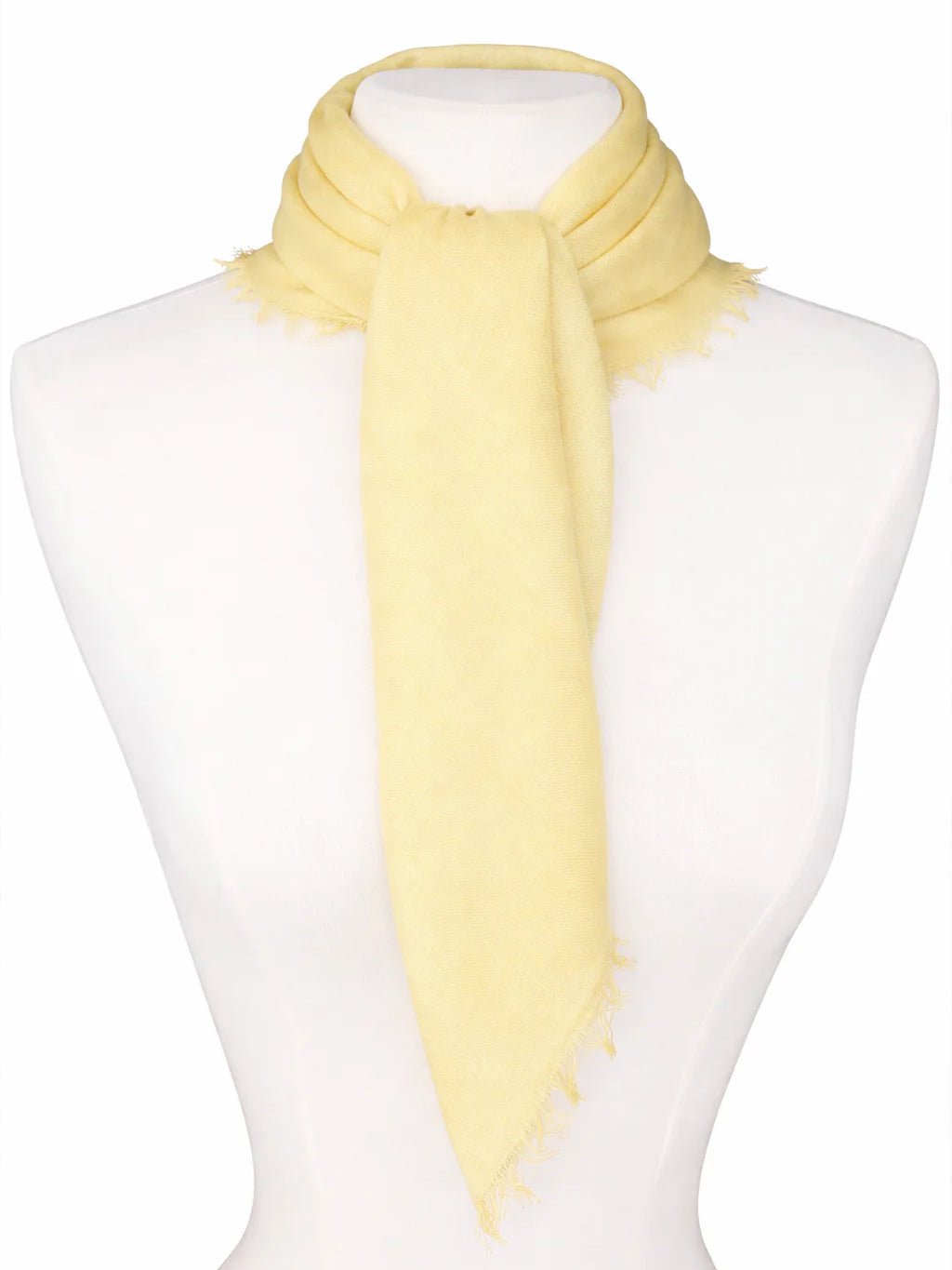 Pale yellow neck scarf tied on a mannequin with fringed edges.