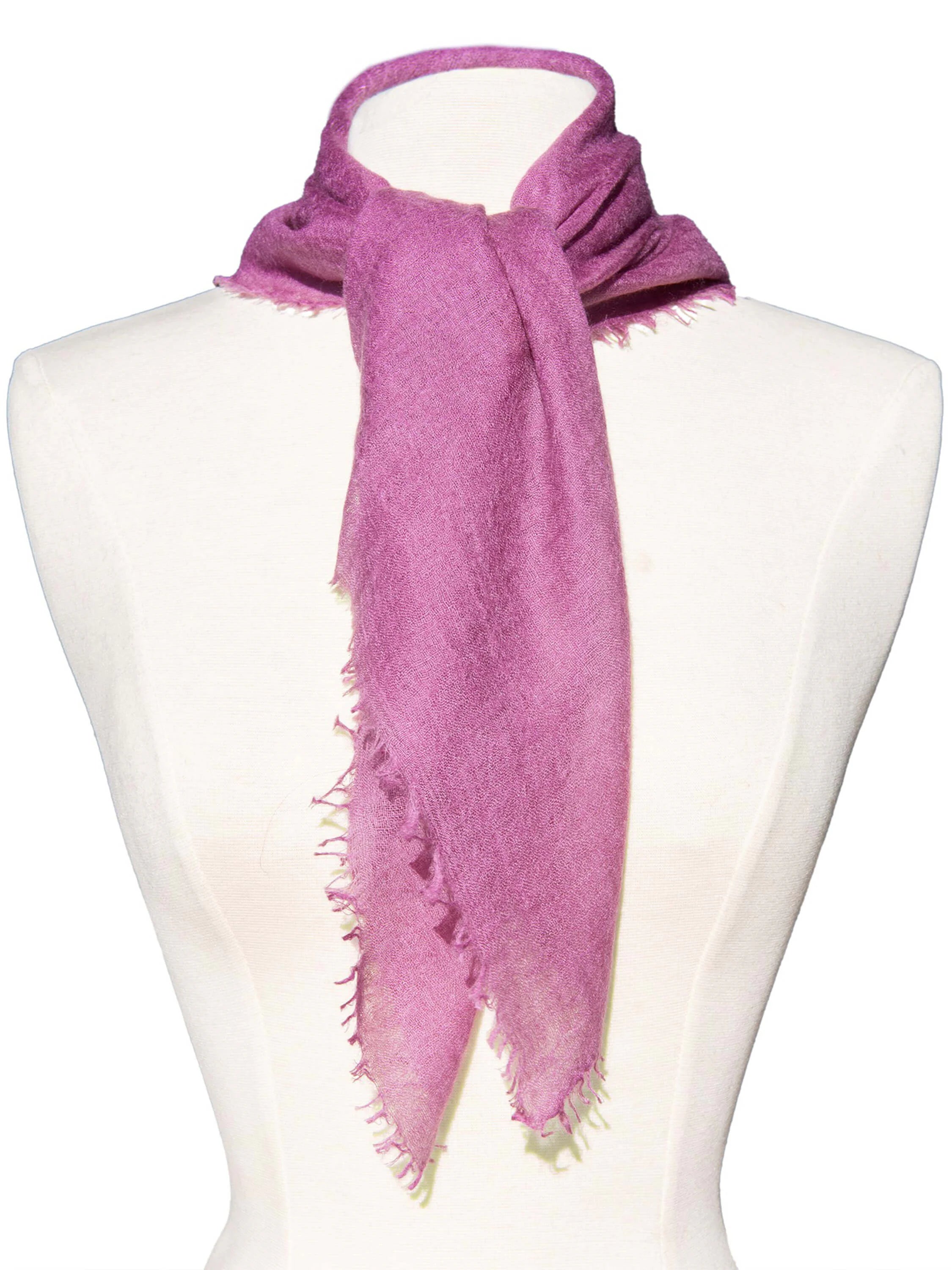 Magenta cashmere neck scarf tied on a mannequin, showing its soft texture and frayed edges.