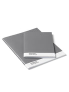 Two notebooks, one larger, one smaller. Both are medium gray with a white band on the cover that reads "PANTONE Cool Gray 9".