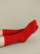 Bright red ribbed socks worn on legs against a neutral background.