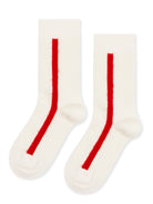 Cream crew socks feature a vertical, thick, vibrant red stripe running down the center of the leg.