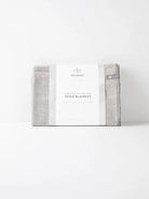 Here's alt text for the image, under 125 characters:

"Handwoven cotton yoga blanket, light gray, folded, with white...