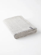Here's alt text for the image, keeping it under 125 characters:

Folded light gray cotton yoga blanket with dark gray...