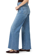 Light blue, wide-leg jeans; frayed hems; burgundy shoes.  Side view.