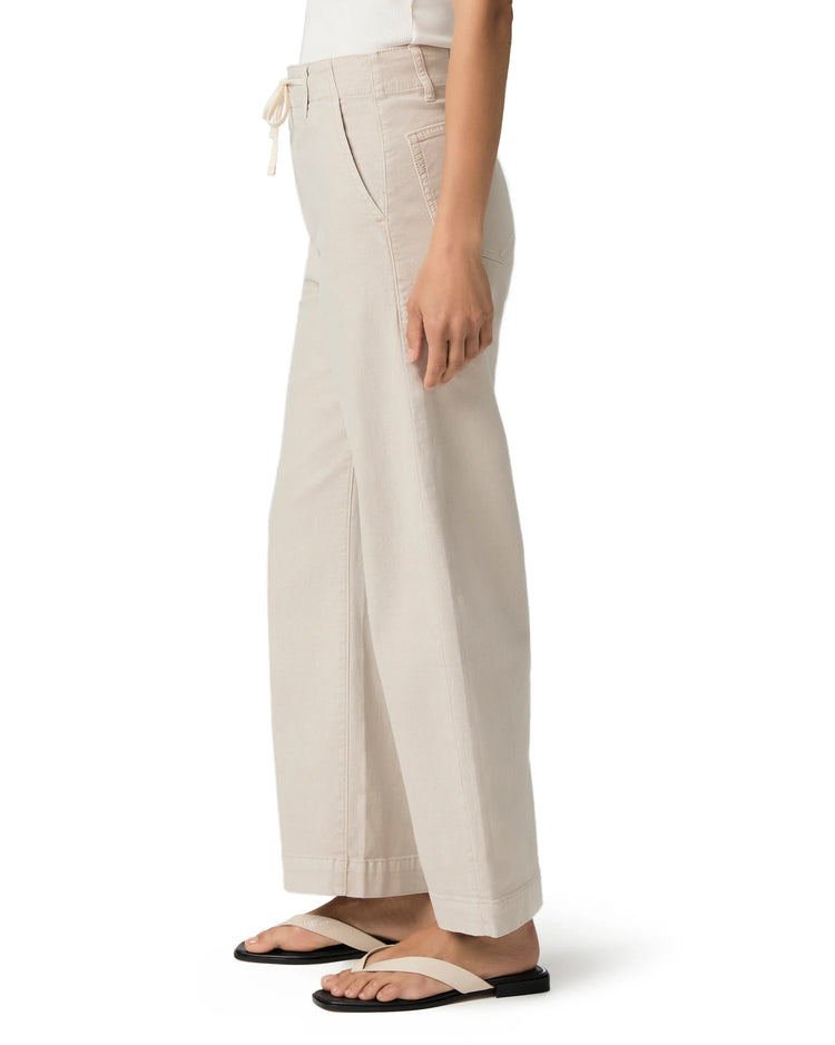 Light beige ankle-length wide-leg pants with a visible drawstring tie at the high waist and side slash pockets.