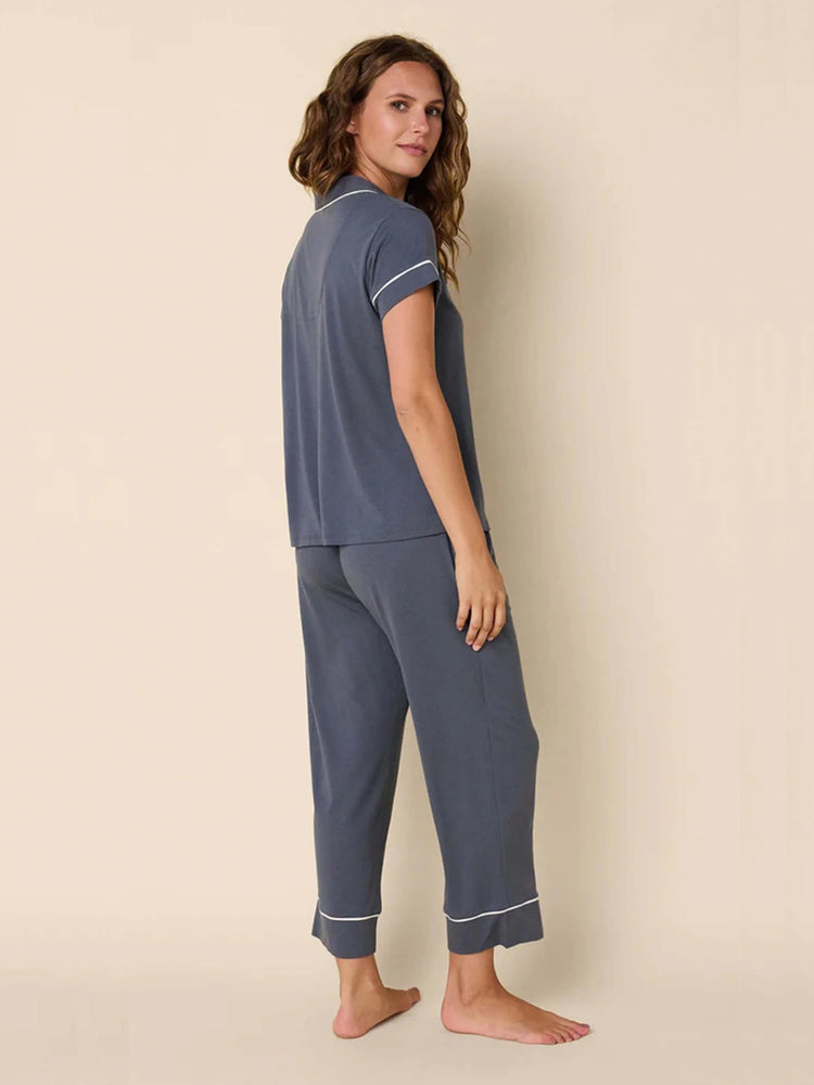 Slate blue pajama set with short-sleeve top & pants. Features white piping on collar, placket, sleeve cuffs, & pant hems.