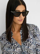 Black angular cat-eye sunglasses with dark lenses and a small gold detail on the temple.
