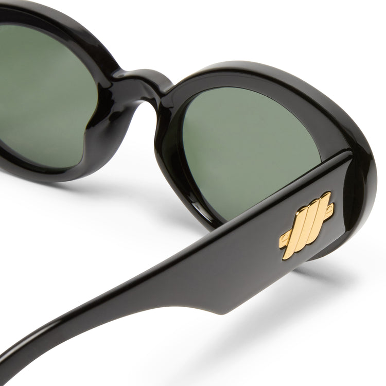 These black oval sunglasses feature green lenses and thick temples accented with a signature gold metal logo.