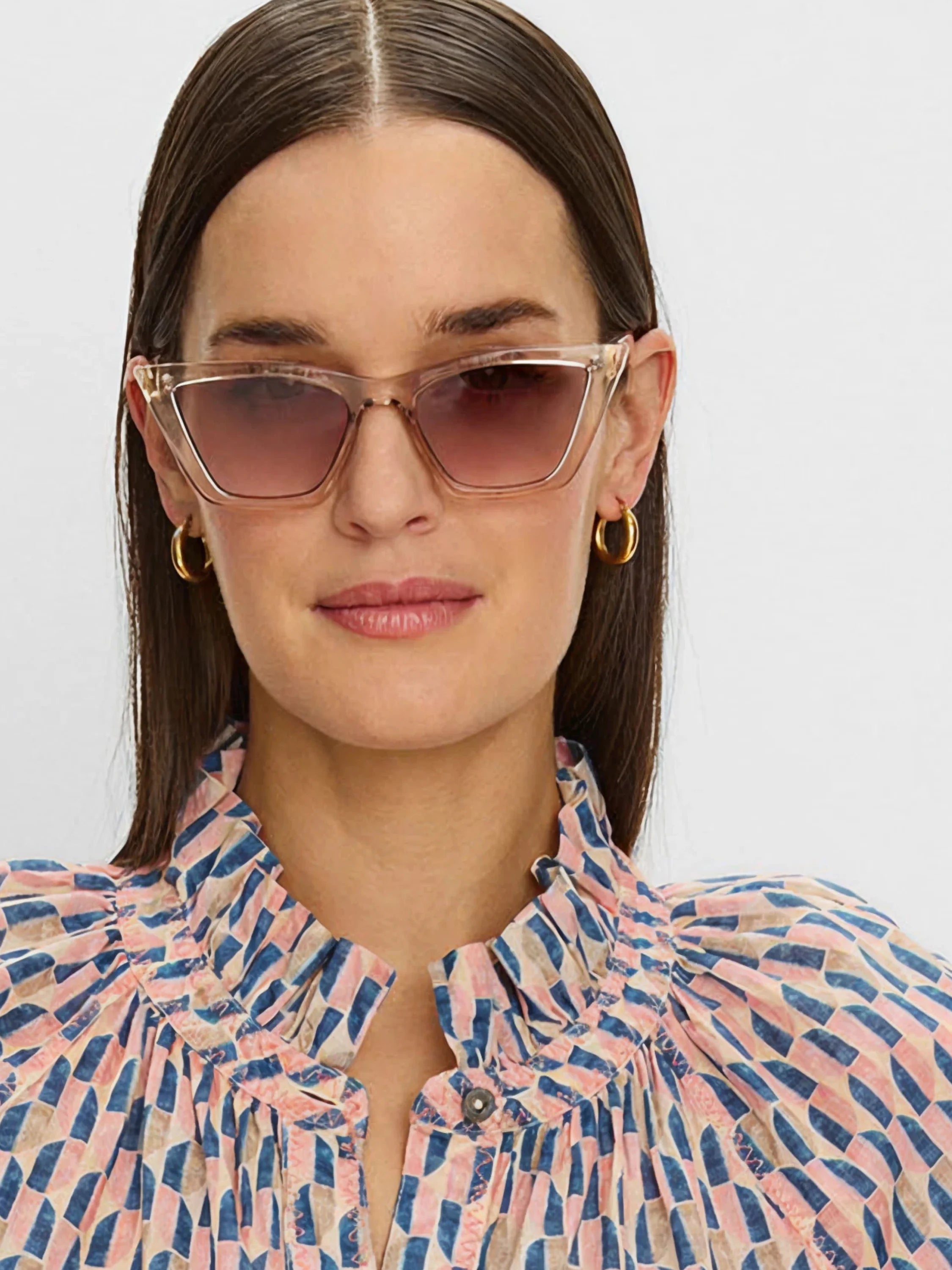 Cat-eye sunglasses with translucent peach frames and brown-to-pink gradient tinted lenses.