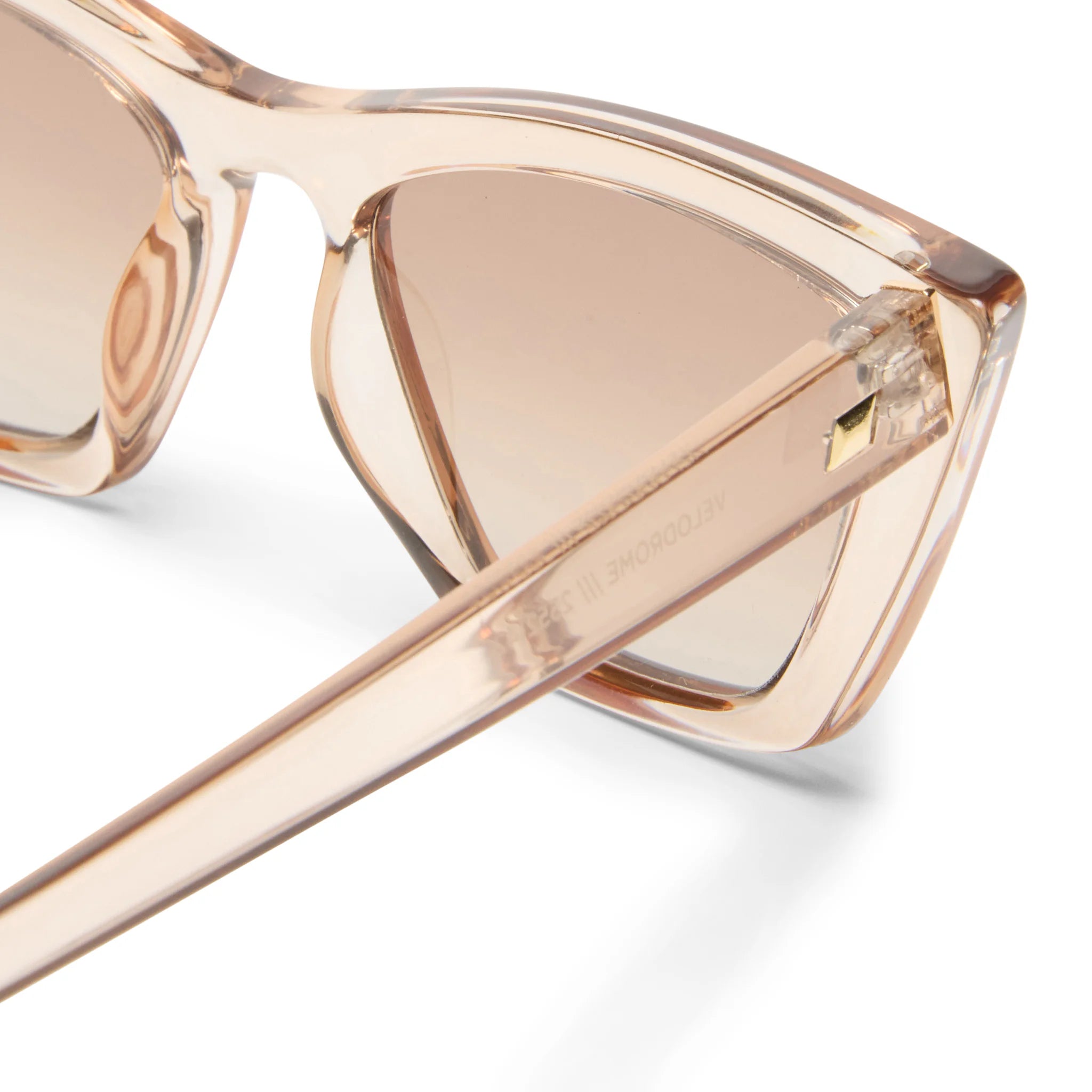 Le Specs Velorome sunglasses: translucent peach frames, gradient brown lenses, gold hinge.