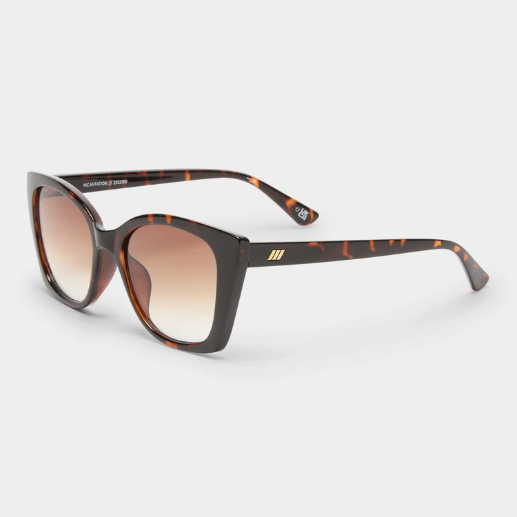 These tortoiseshell cat-eye sunglasses feature an oversized fit, gradient brown lenses, and gold temple accents.