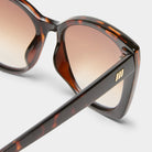 Oversized tortoise shell sunglasses featuring brown gradient lenses and gold logo hardware on the temples.