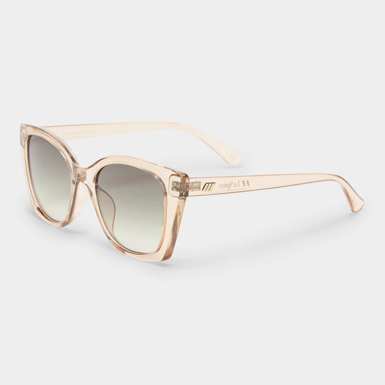 These oversized square sunglasses feature translucent peach frames with gradient lenses and gold temple accents.