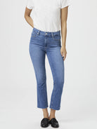Mid-rise, light-wash blue cropped flare jeans with a raw hem.  Model wears black loafers.