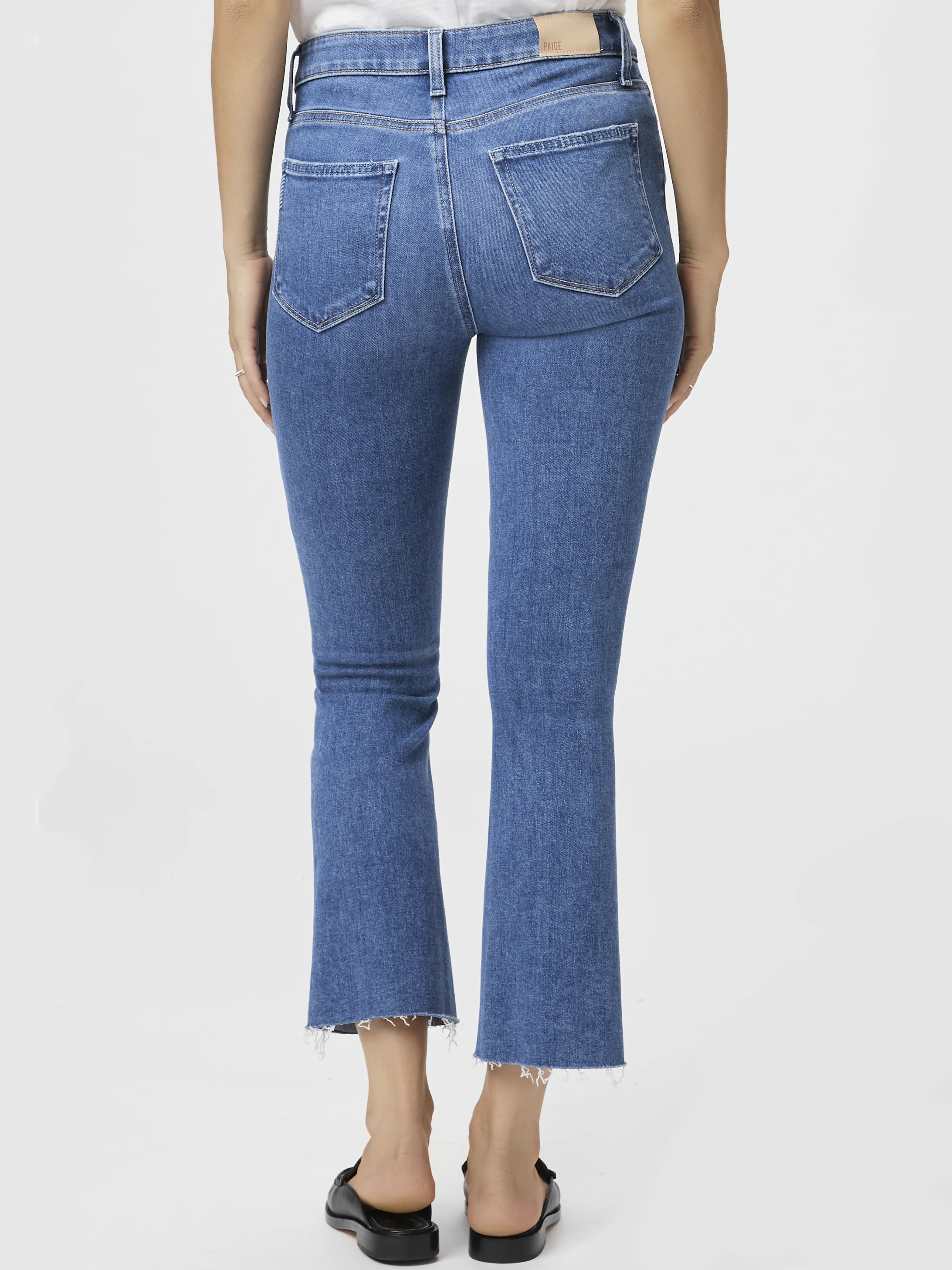 Here's alt text under 125 characters:

Mid-rise, cropped blue jeans, flared legs with raw hem.  Back view.