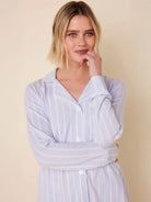 Light blue long-sleeve pajama top with thin white vertical stripes, white piping on collar and cuffs, and white buttons.