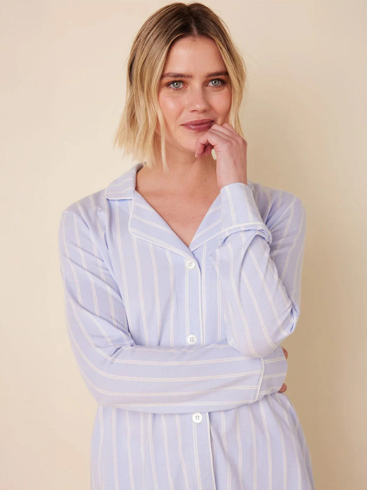 Light blue long-sleeve pajama top with thin white vertical stripes, white piping on collar and cuffs, and white buttons.