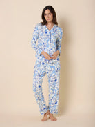 White long-sleeve pajama set with blue floral, leopard, and bird patterns. Blue piping trim.