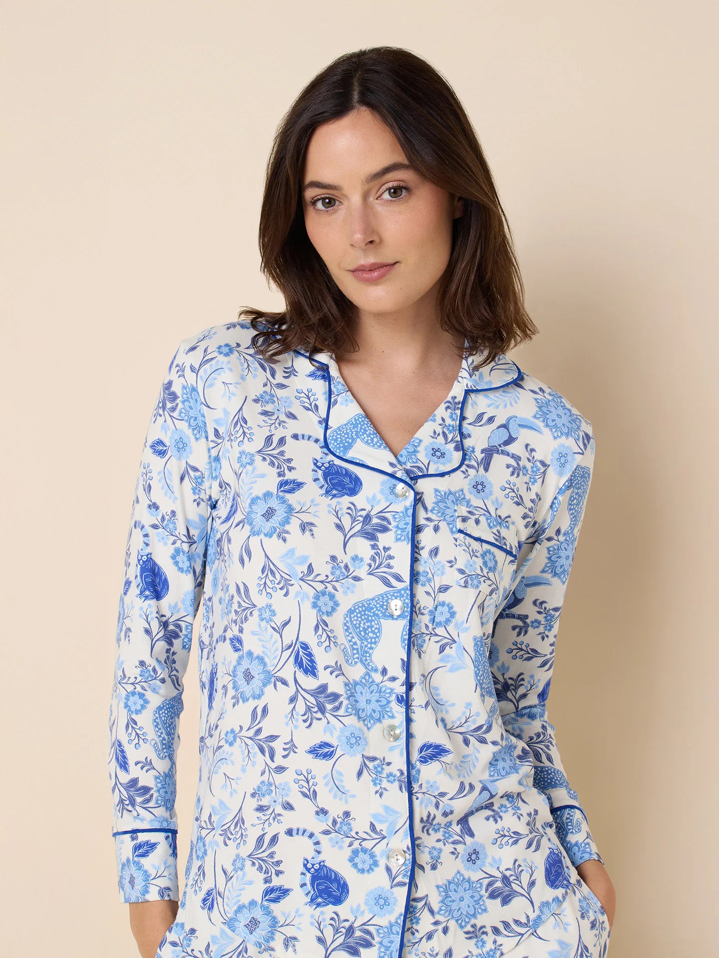 White long-sleeve pajama set with blue floral and cat print, accented by blue piping on collar and cuffs.