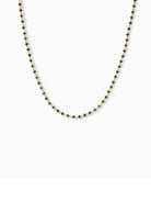 Gold chain necklace with small, dark-blue beads.