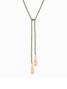 Here's some alt text that meets the requirements:

Dark-grey beaded lariat necklace with two gold teardrop charms.