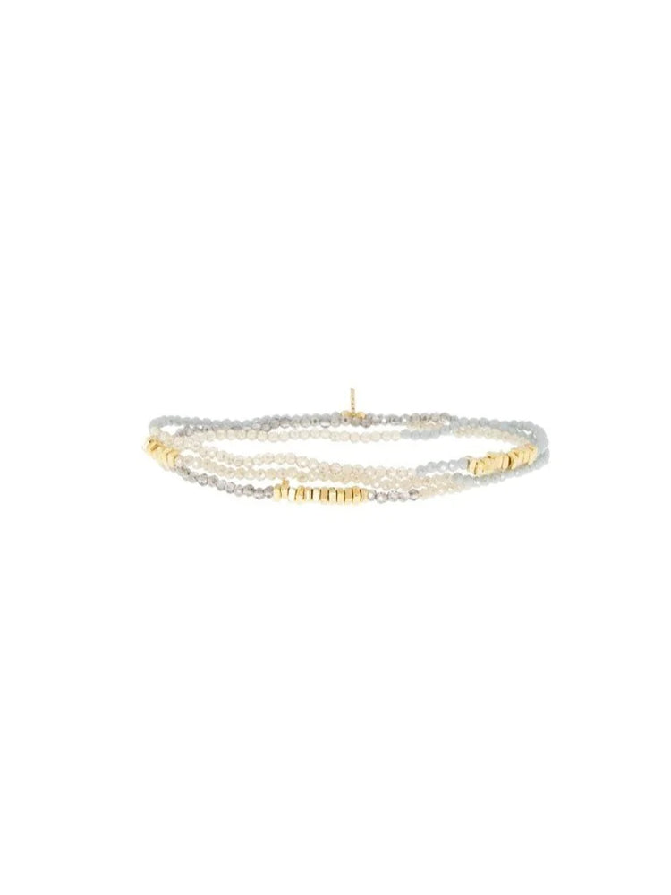 Multi-strand crystal wrap bracelet with light grey and pale cream faceted beads, accented with small gold-toned beads.