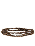 Three-strand bracelet with dark brown faceted beads and a centered, elongated cream pearl.
