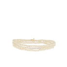 Cream multi-strand faceted bead stretch bracelet with a long white pearl bar.