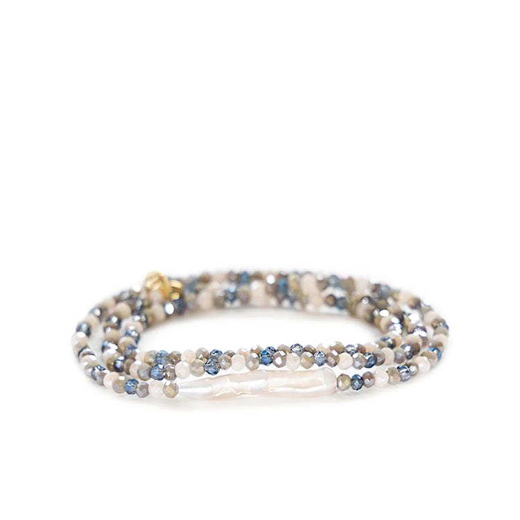 Stretch bracelet coiled, with iridescent blue, grey, cream faceted beads, and a long white baroque pearl.