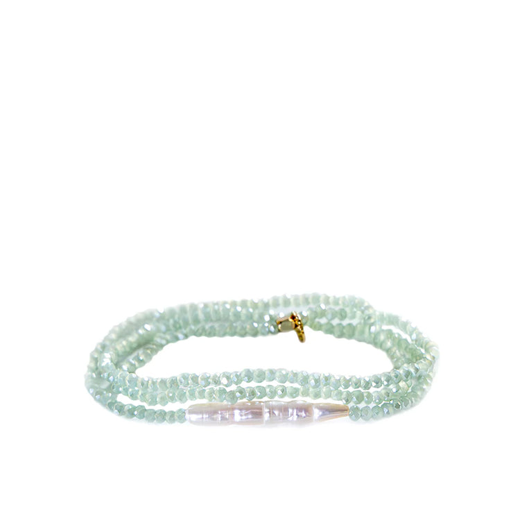 Multi-strand bracelet of small, faceted mint green beads with a central white bar pearl.