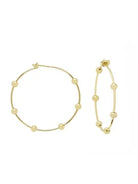 Two gold hoop earrings with small, round gold beads spaced along the hoops. One large earring, one smaller.