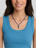 Lapis beaded necklace with dark blue fish pendant, light blue stripe, green accent, and gold details.