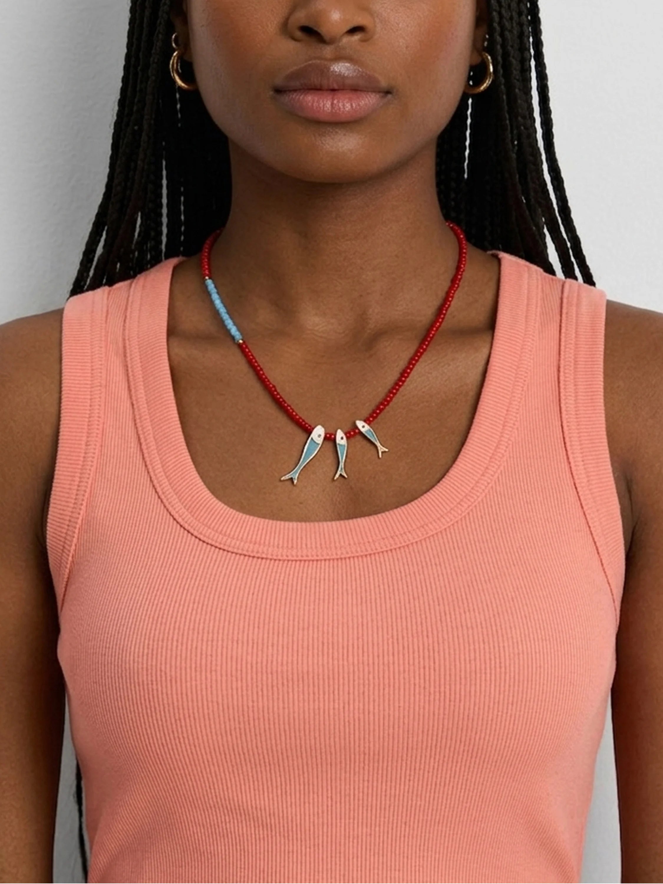 Necklace with red and light blue beads, three silver fish charms with blue details.