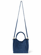 Dark blue suede satchel bag with gold-tone hardware and long shoulder strap.