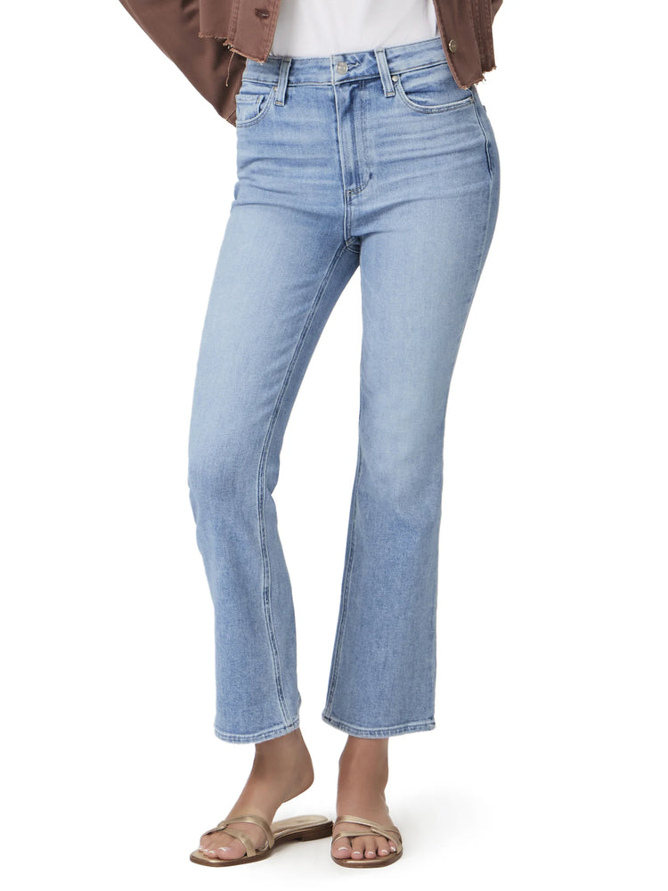 Light wash, ankle-flare jeans on a model.  The jeans are a light blue denim.  The model is wearing gold sandals.