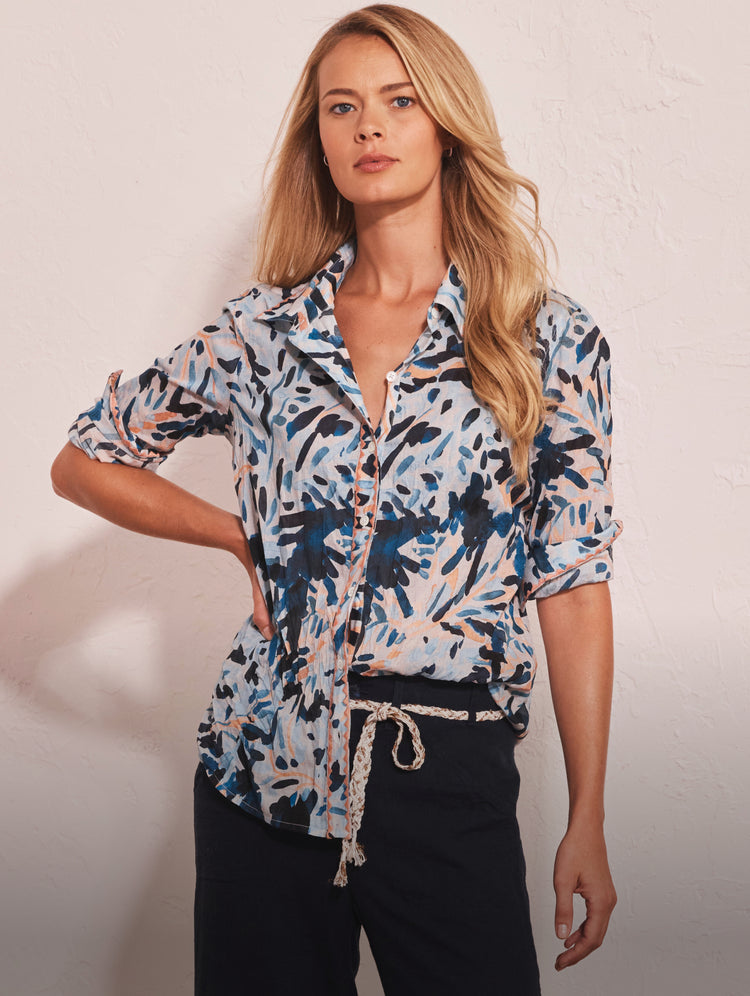 Woman wearing a patterned shirt with a plain background