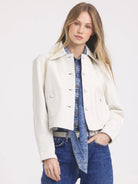 Cream cropped leather jacket with collar, front buttons, and two large chest pockets.