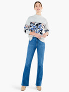 Here's alt text for the image, following the guidelines:

"Mid-rise, bootcut jeans; medium-wash blue denim with raw hem....
