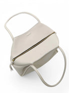 Off-white tote bag with top handles and gold zipper.