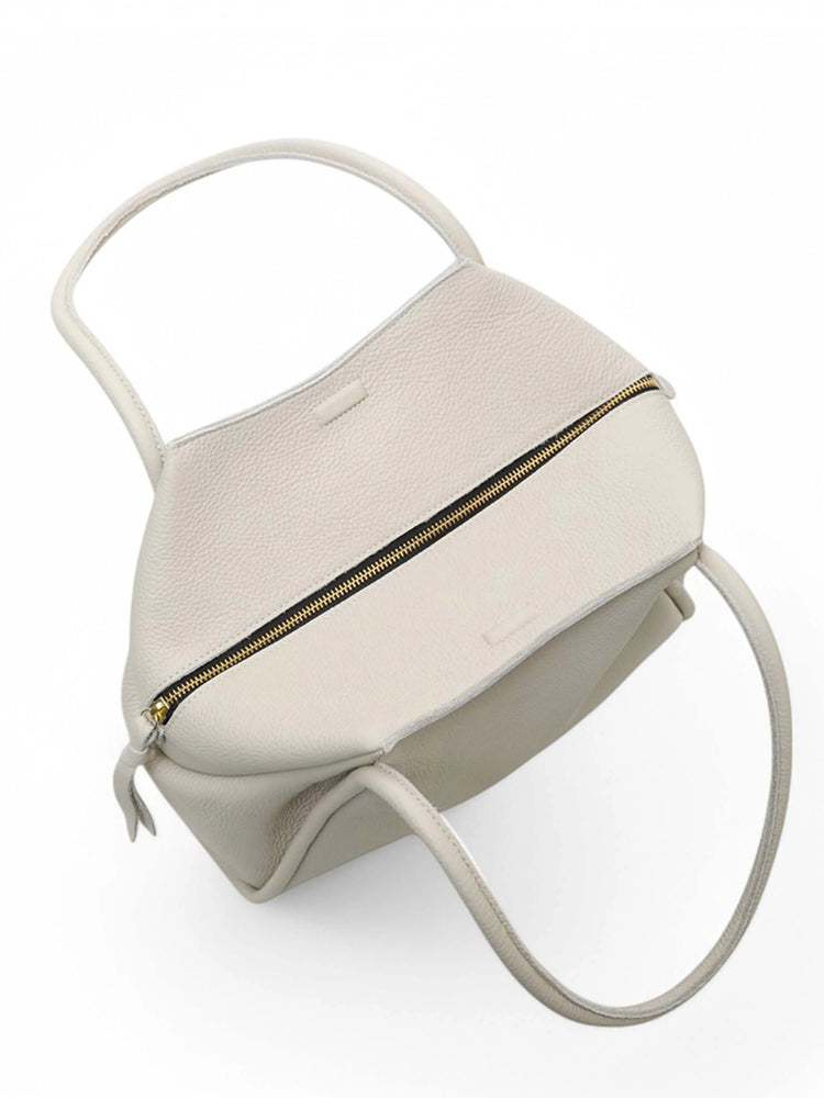 Off-white tote bag with top handles and gold zipper.