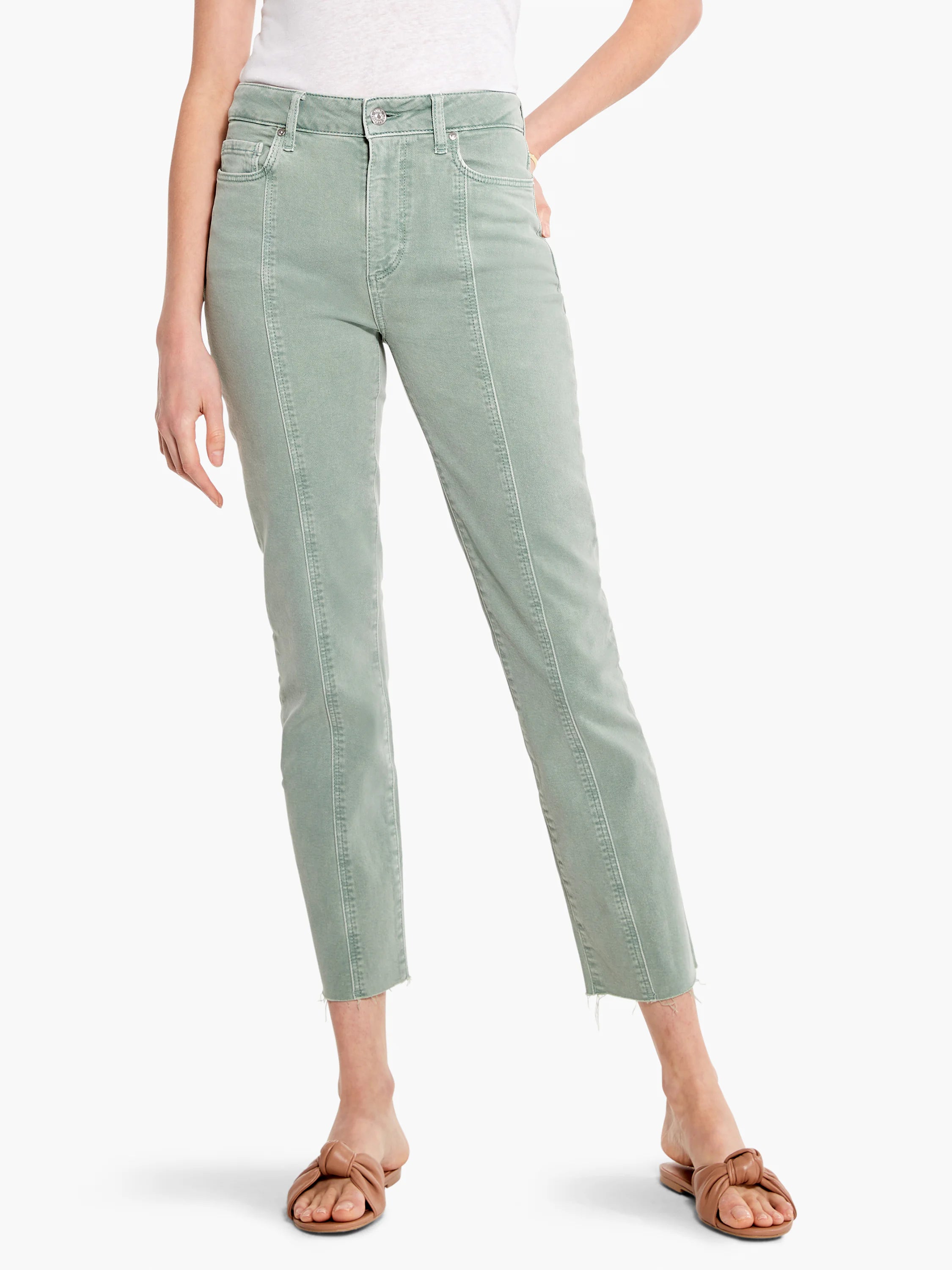 Light green jeans with vertical front seams and raw, frayed hems, worn by a model.