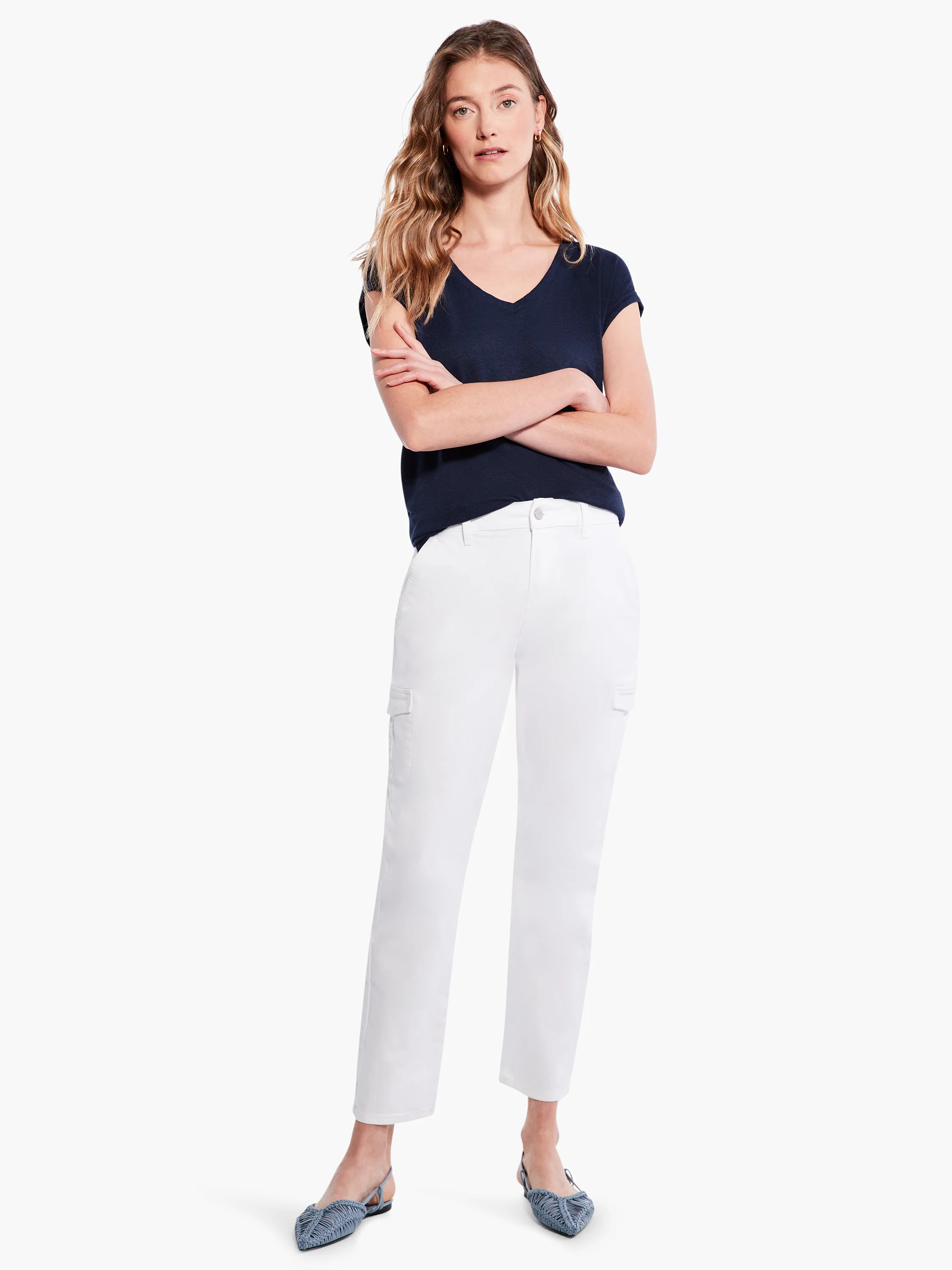 White cargo pants with side pockets; model wears dark navy top and light blue shoes.