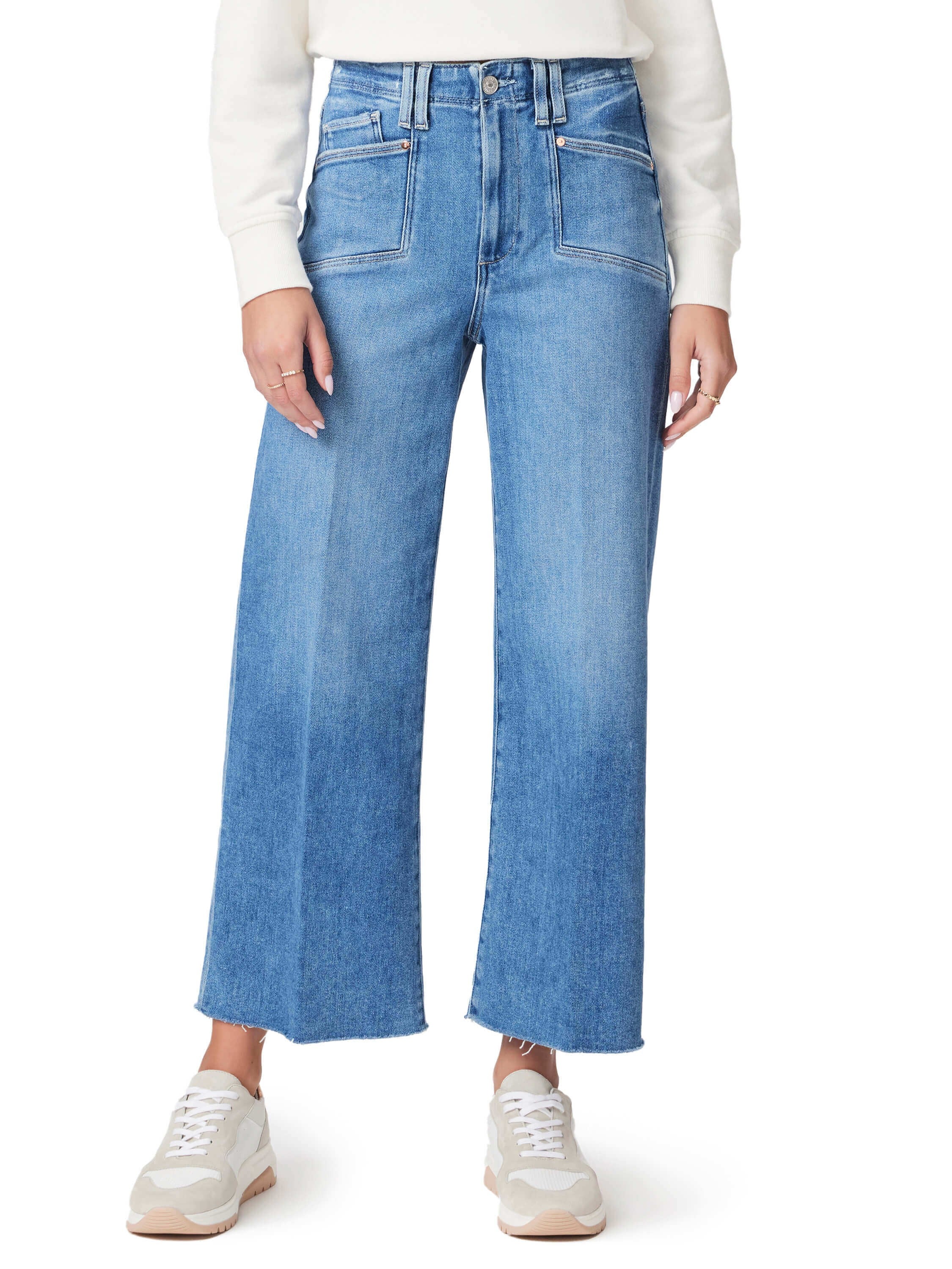 Light wash blue, wide-leg jeans with high waist and patch pockets.  Raw hem. Model wears off-white sneakers.